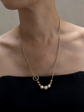 Load image into Gallery viewer, A woman wears the Trio of Vintage Pearls and 14K Beads on a 14K Gold Chain with Toggle Closure, featuring alternating vintage pearls and gold beads. The T-bar toggle necklace graces her collarbone above a black strapless top against a neutral backdrop.