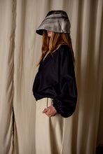 Load image into Gallery viewer, A woman wearing a black shirt and white pants, paired with Noir de Chine crafted from Japanese wool gauze.