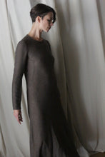 Load image into Gallery viewer, A woman with short dark hair, in a handmade brown Long Sleeved Crewneck Dress, stands before light draped curtains, looking down thoughtfully.