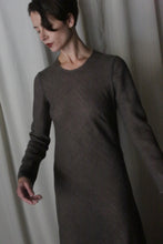 Load image into Gallery viewer, A person with short dark hair models the Long Sleeved Crewneck Dress, arms slightly extended against a light backdrop, showcasing the timeless style of this handmade San Francisco piece.
