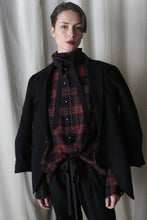 Load image into Gallery viewer, A person stands before a light curtain in a black jacket over a Simple Shirt | Japanese Wool Gauze Wine Plaid, flaunting a ruffled collar and black ribbon tie. With short hair and dark lipstick, they gaze directly at the camera.
