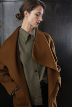 Load image into Gallery viewer, A woman with short dark hair, tied back, gazes sideways with a serious expression. She wears a large, tobacco-colored Winston Long Double-face coat over a grey, textured, collared shirt. The relaxed construction and the dark background add contrast to her light skin and subdued, elegant outfit.