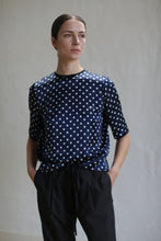 Load image into Gallery viewer, A woman in a pure silk charmeuse Crewneck Tee | Navy Polkadot.