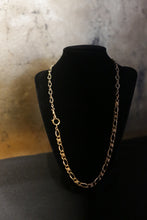 Load image into Gallery viewer, Displayed on a black velvet stand against a textured background, the Antique Gold Filled Twisted Curb Chains c.1890 and 1940 showcases interlocking oval links and a circular clasp. The soft, warm lighting highlights the elegant simplicity of this vintage necklace.