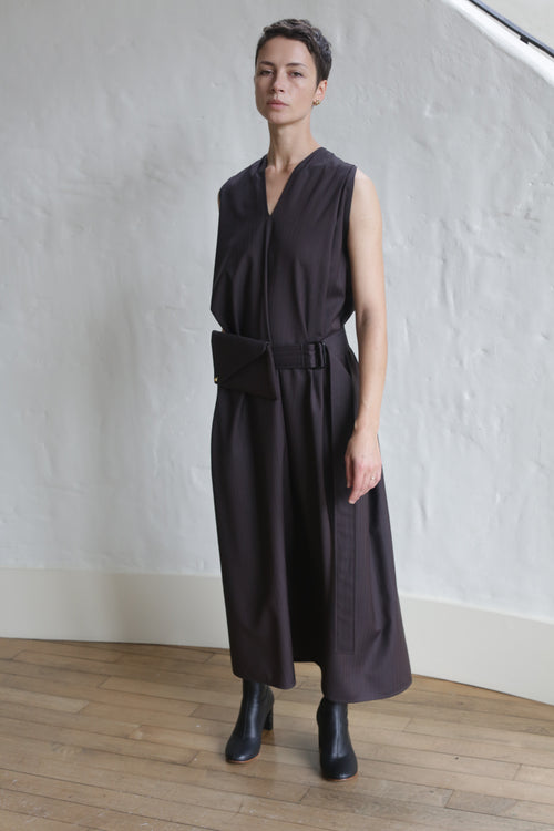 A woman in a Belted Dress made of wool herringbone in brown.