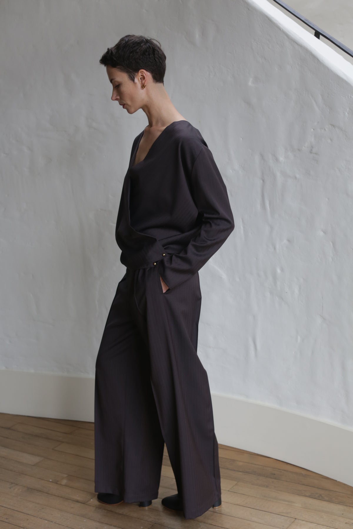 A person wearing brown wool herringbone trousers.