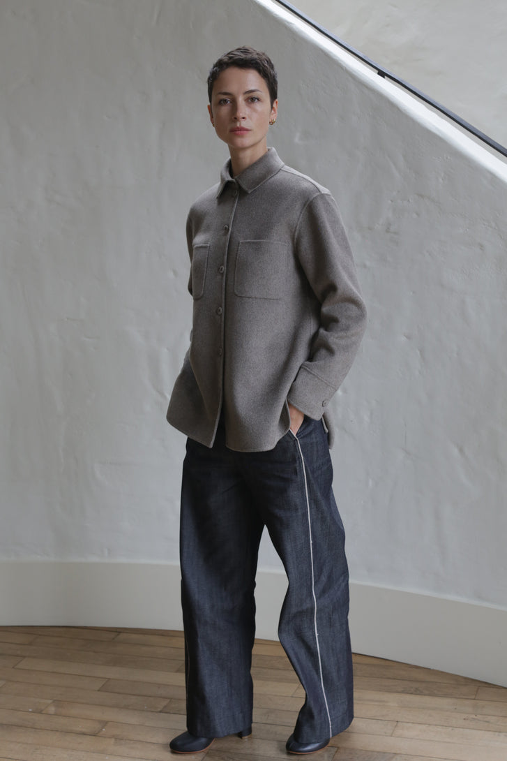 A person wearing Denim Trousers stands on a staircase.