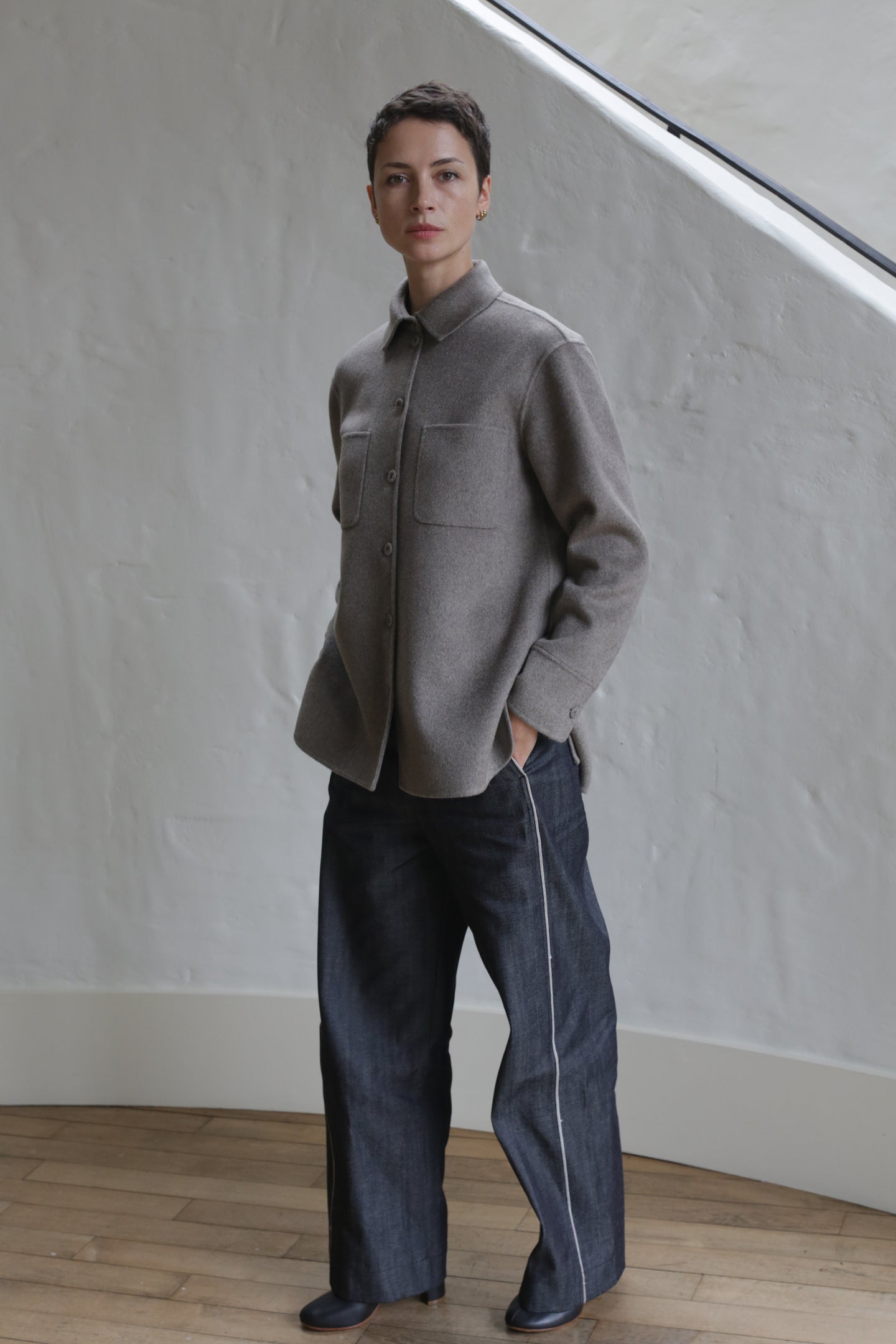 A person wearing Denim Trousers stands on a staircase.