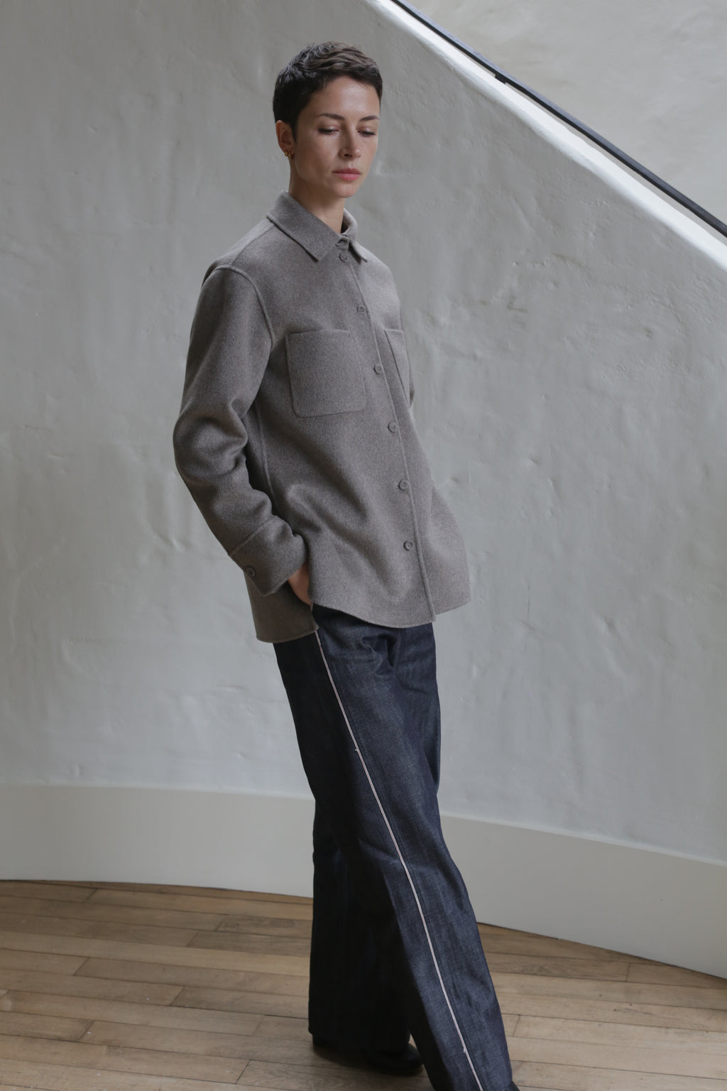 A person wearing Denim Trousers stands on a staircase.