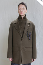 Load image into Gallery viewer, A woman wearing the Sculptor&#39;s Jacket in Olive with sunglasses in her pocket.