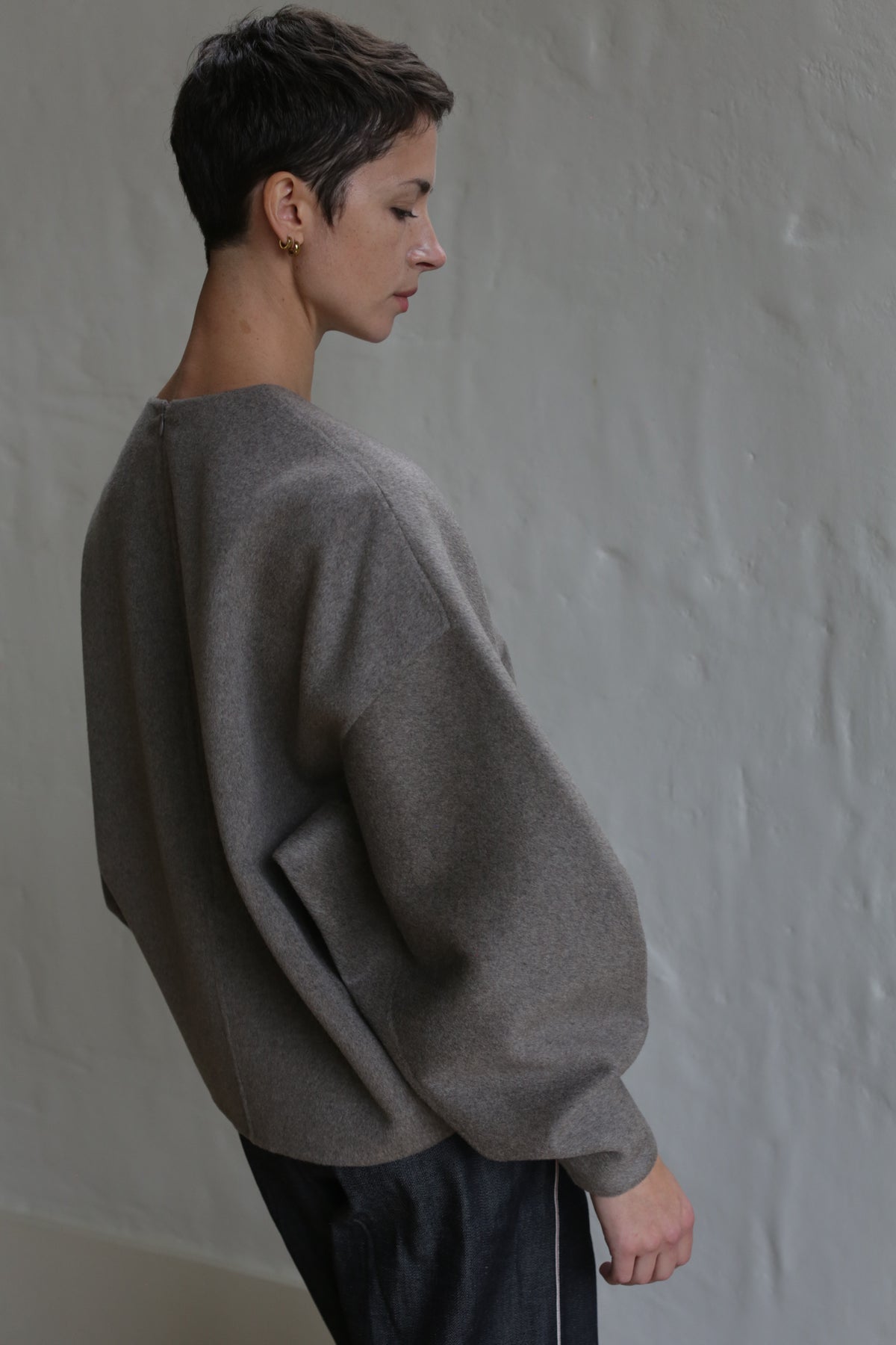 A woman in the Cocoon sweater in undyed natural.