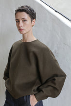 Load image into Gallery viewer, A woman with short hair wearing the Cocoon sweater in olive.