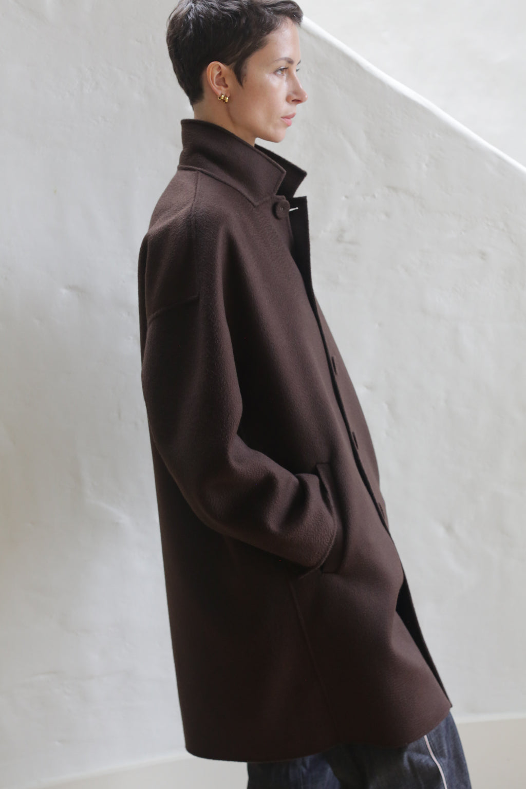 A person wearing the Men's Coat in Watermark Brown.