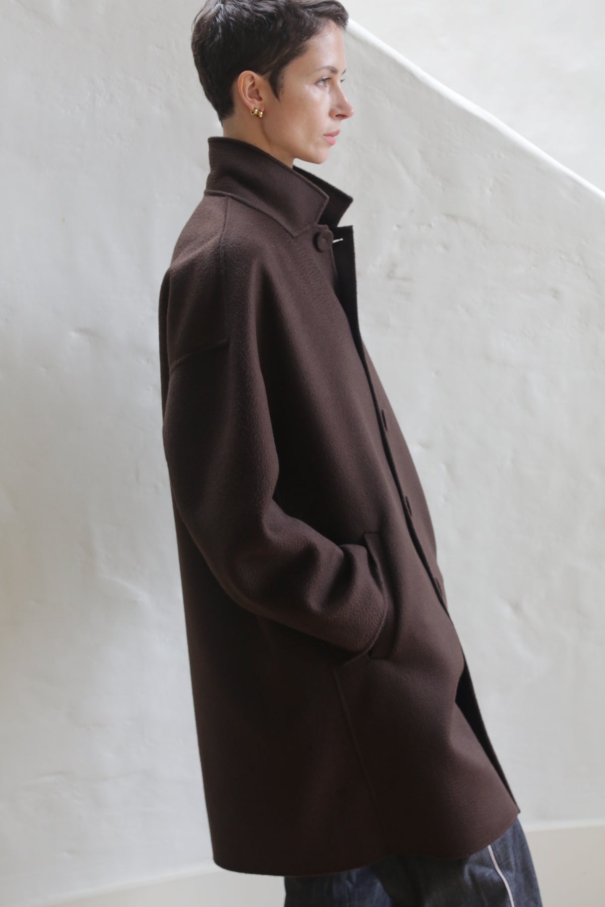 A person wearing the Men's Coat in Watermark Brown.