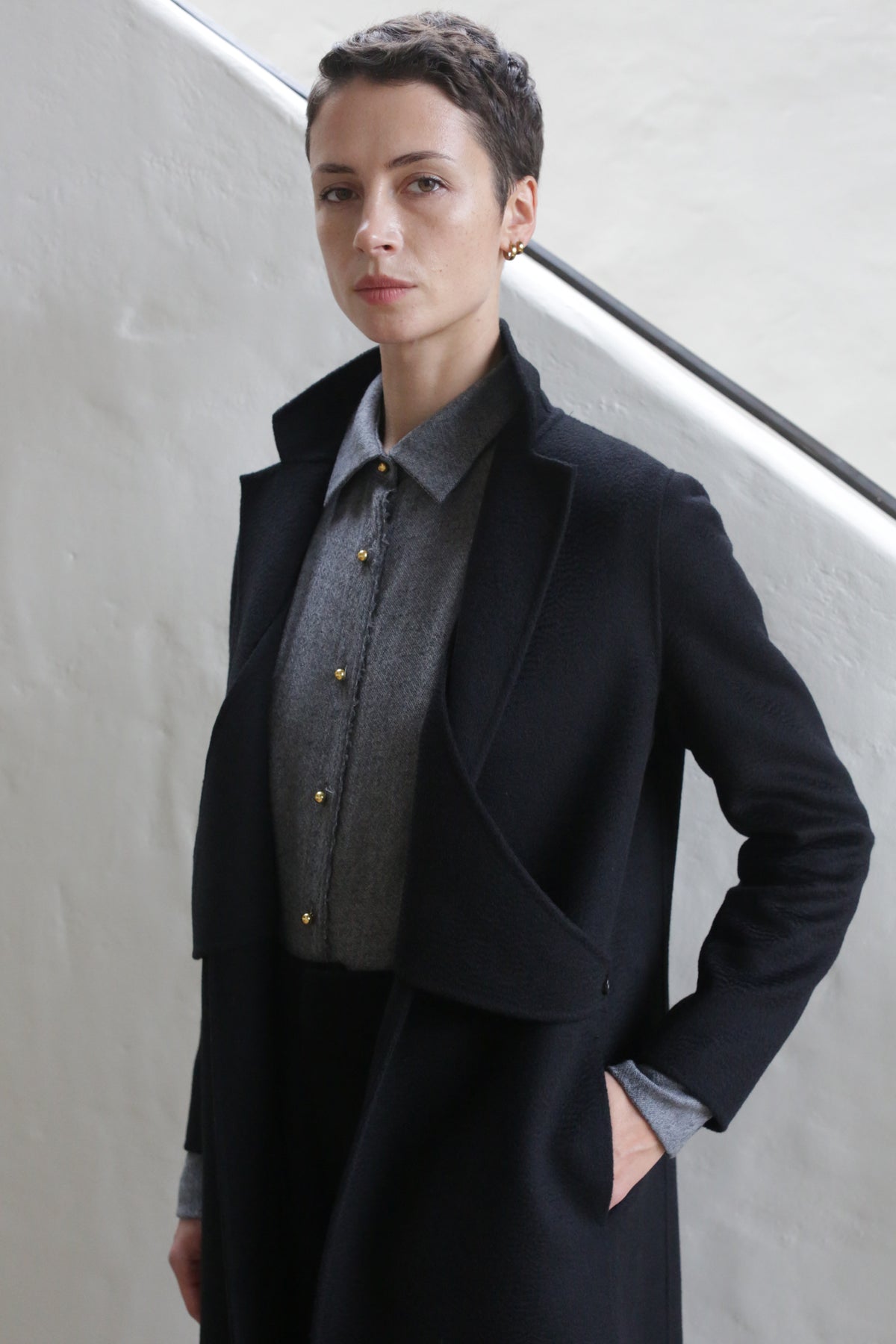 A woman wearing the X-Scarf Coat in Watermark Black.