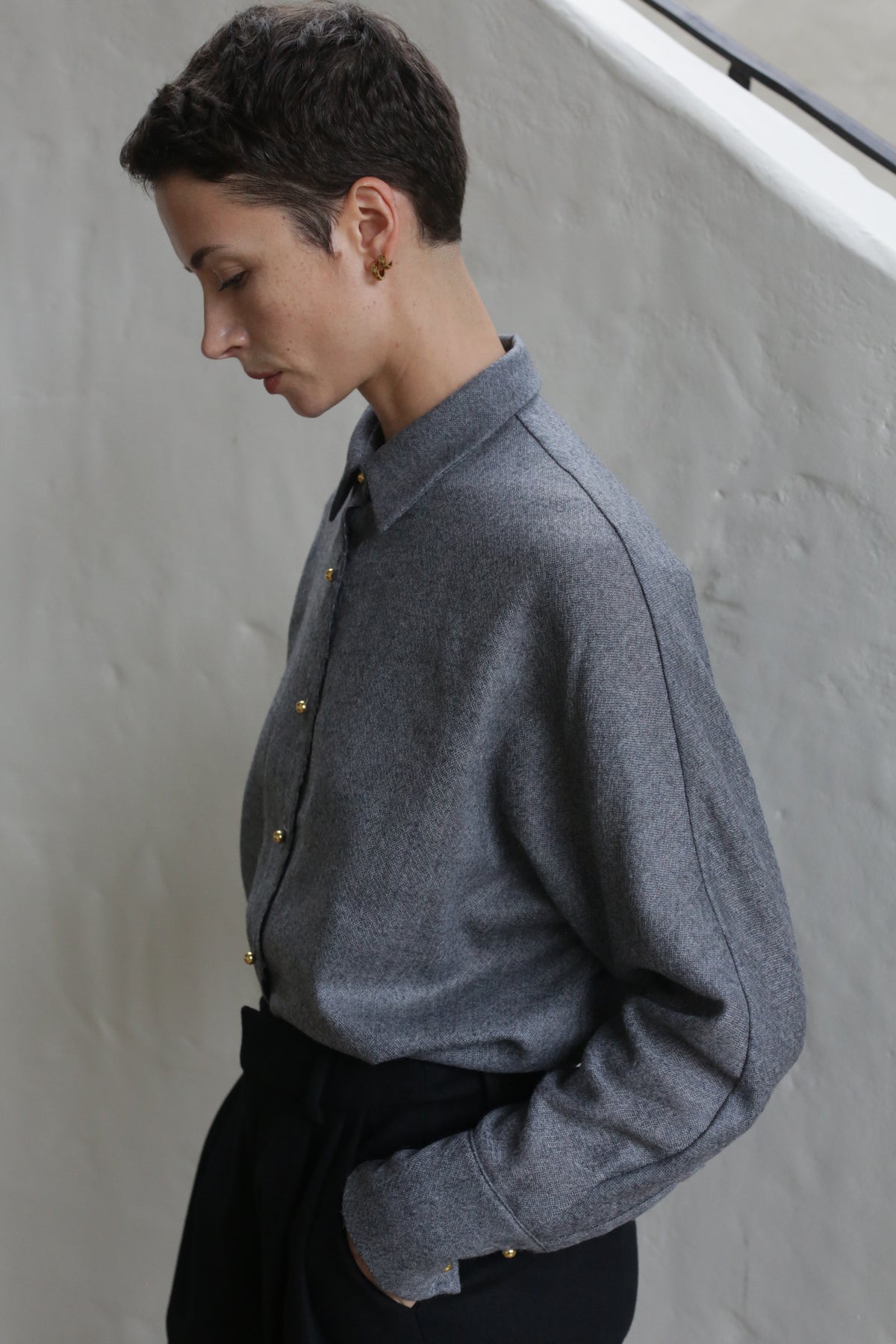 A woman with short hair is wearing the Work Shirt in Grey.