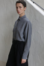 Load image into Gallery viewer, A person with short hair, dressed in the Work Shirt | Grey and black pants, stands beside a light-colored wall, looking calmly at the camera.
