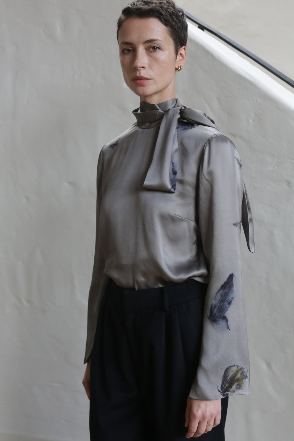 A woman in a Sash Blouse with a small butterflies print.