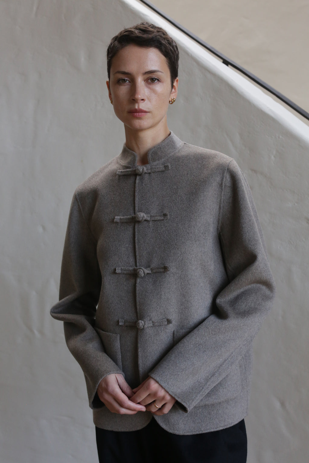 A woman wearing the Mandarin Jacket in undyed natural.