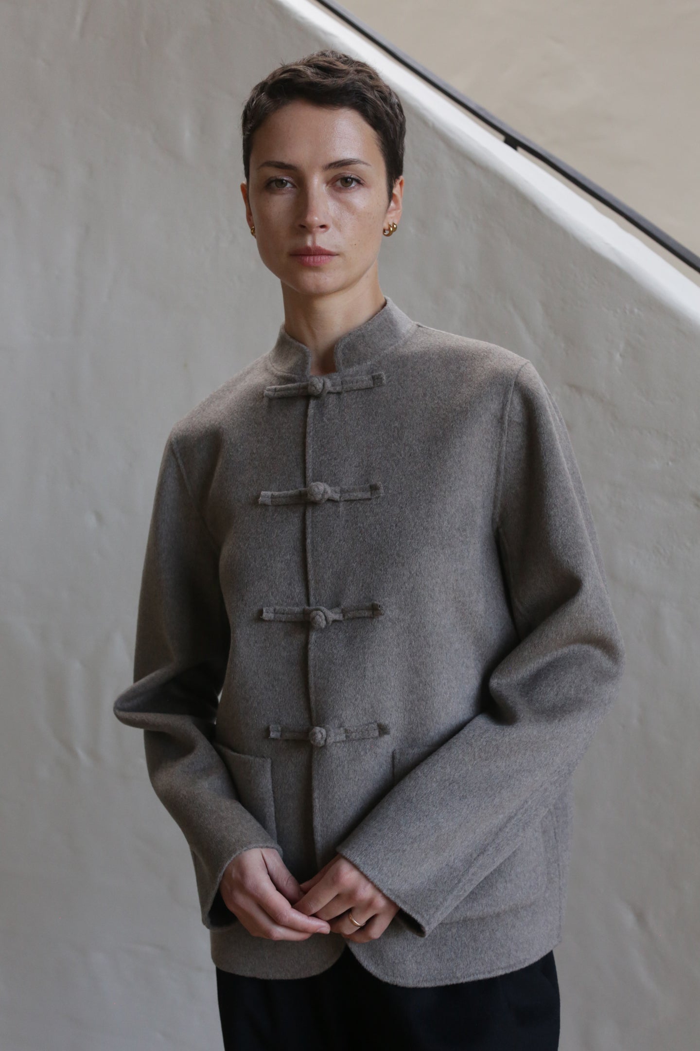 A woman wearing the Mandarin Jacket in undyed natural.