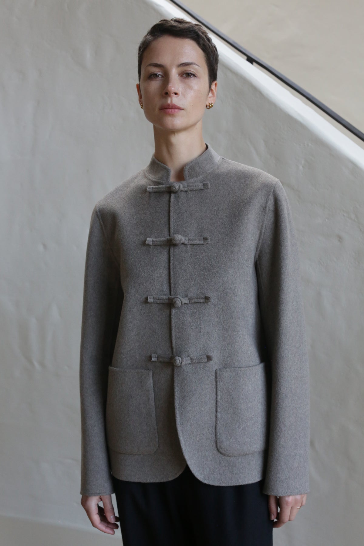 A woman in a Mandarin Jacket in undyed natural color.