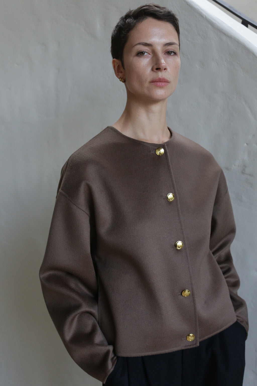A woman wearing the Cocoon Jacket in Taupe.