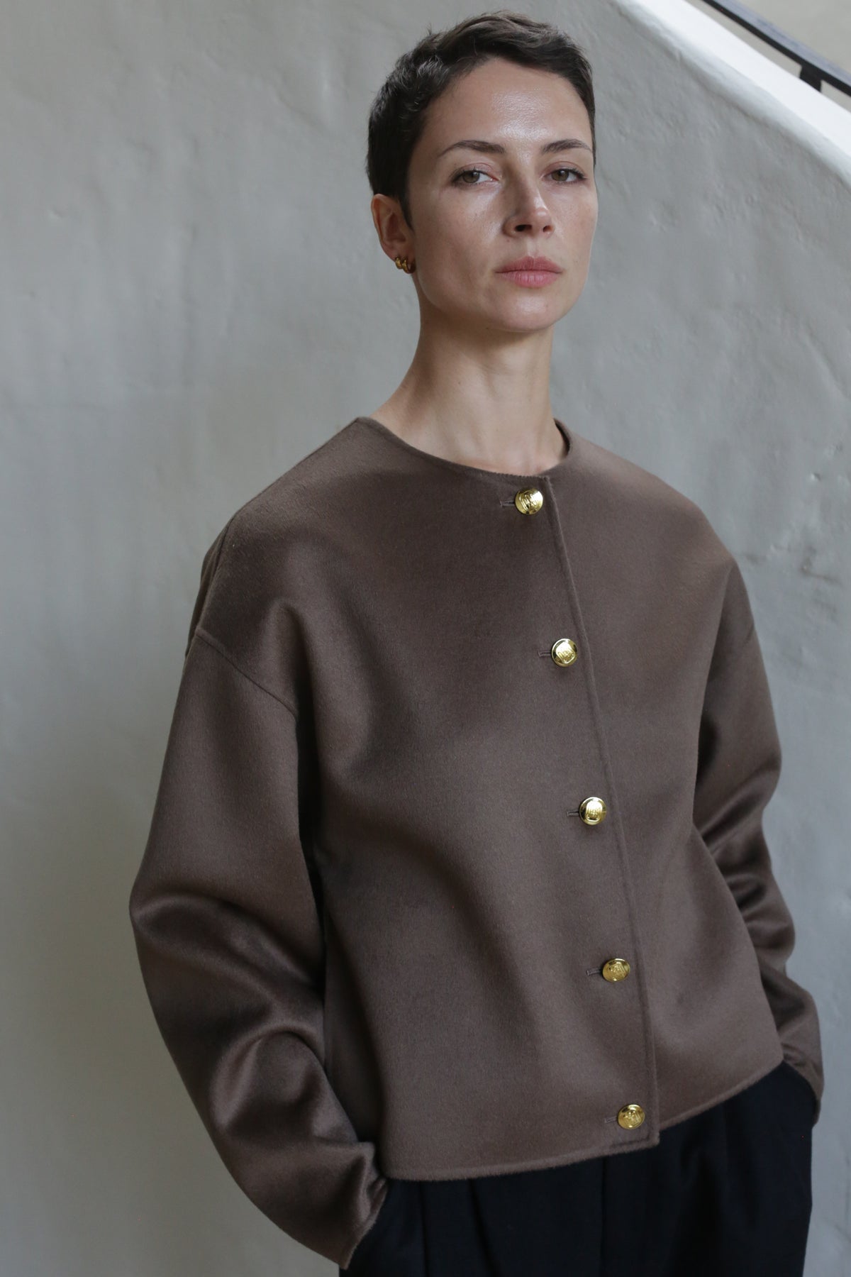A woman wearing the Cocoon Jacket in Taupe.