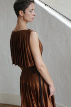 Load image into Gallery viewer, A woman in a Hand Pleated Column Dress crafted from silk charmeuse in copper.