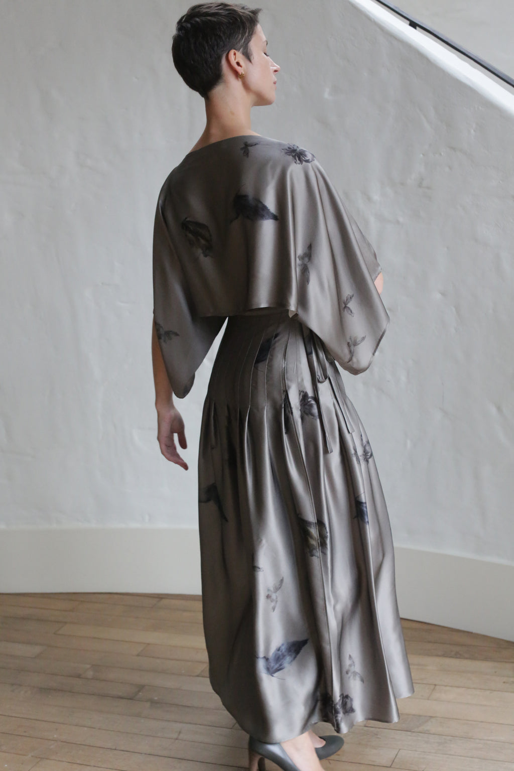 A woman in a Hand Pleated Kimono Dress featuring a Small Butterflies design.