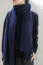 Load image into Gallery viewer, A person with fair skin, dressed in a black long-sleeve top and wearing a navy Tissue Weight Cashmere Scarf, along with red lipstick, stands against a light-colored background. Their head is partially visible with the focus on their torso and the scarf.