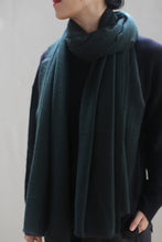 Load image into Gallery viewer, A person is wearing a Tissue Weight Cashmere Scarf in Hunter Green, elegantly wrapped around their neck and paired with a dark long-sleeve top. The photo is cropped to show only the lower half of the person&#39;s face and torso, with an out-of-focus background that highlights the cashmere scarf and clothing.