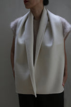 Load image into Gallery viewer, A person with short dark hair is wearing a Wrap Scarf in the undyed color over a fuzzy-sleeved shirt. The image is cropped to focus on the upper body, and the background is blurred. The lips are painted red, but the rest of the face is not visible.