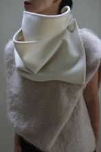 Load image into Gallery viewer, A person is wearing a high-fashion outfit featuring a large, structured white collar that buttons on the side. The fuzzy gray Wrap Scarf, made from undyed double-face cashmere, lends a textured, wooly appearance to the look. The image focuses on the upper body and highlights the detailed design of this zero waste clothing piece.