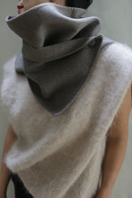 Load image into Gallery viewer, A person is wearing a large, textured, off-white Wrap Scarf | Undyed Natural from Atelier Lan Janicke around their neck. The scarf is partly covering their face and the background features a light, neutral color. Both pieces are handmade using undyed double-face cashmere for a zero waste design.