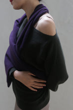 Load image into Gallery viewer, A woman stands with her arms crossed, wearing an olive-colored Ballerina&#39;s Cashmere Sweater in a relaxed fit with one shoulder exposed. A purple scarf is draped over her shoulders, creating a striking contrast with the outfit against a plain, light gray background.