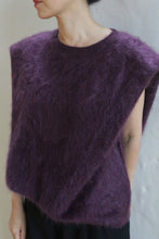 Load image into Gallery viewer, A person stands against a plain light background wearing the Salento | Aubergine sleeveless brushed cashmere top with a wide neckline, head turned to the side and hands behind their back.