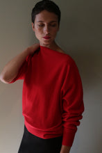 Load image into Gallery viewer, A person wearing the Ballerina’s Cashmere Sweater | Vermillion, a bright red, boat-neck cashmere sweater with a relaxed silhouette.
