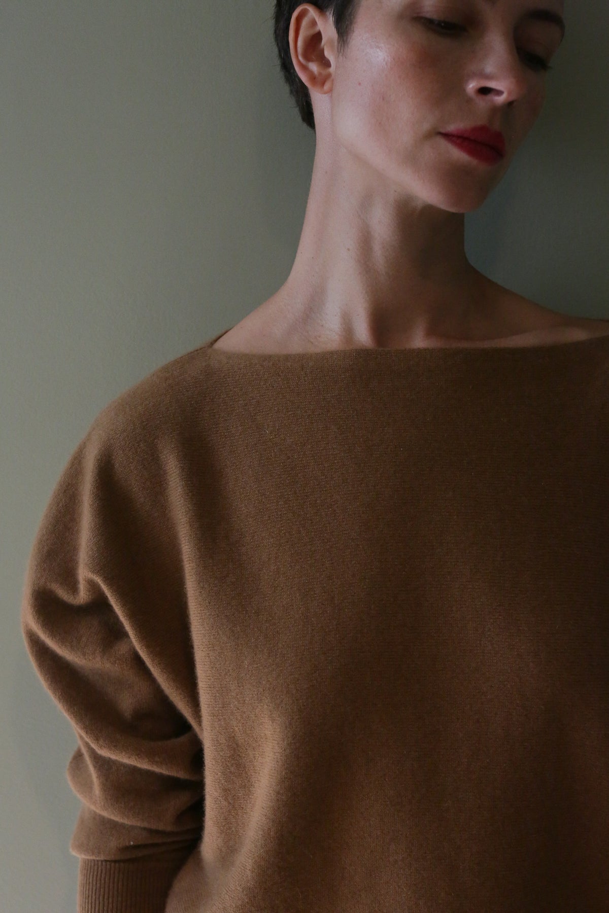 A person wearing a brown Ballerina’s Cashmere Sweater | Vicuna featuring a relaxed silhouette and a boat neck.