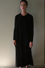 Load image into Gallery viewer, A person wearing a long-sleeved, ankle-length black Cashmere Sweater Dress.
