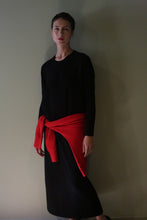 Load image into Gallery viewer, A person wearing a black Cashmere Sweater Dress in a midi length with a red sweater tied around their waist.