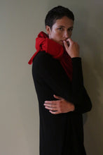 Load image into Gallery viewer, A person wearing a black Cashmere Sweater Dress with a bright red scarf draped over their shoulders.