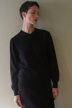 Load image into Gallery viewer, A person with short dark hair wears a black High V-Neck Cashmere Sweater.