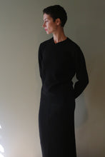 Load image into Gallery viewer, A person wearing a High V-Neck Cashmere Sweater| Black with a matching skirt.