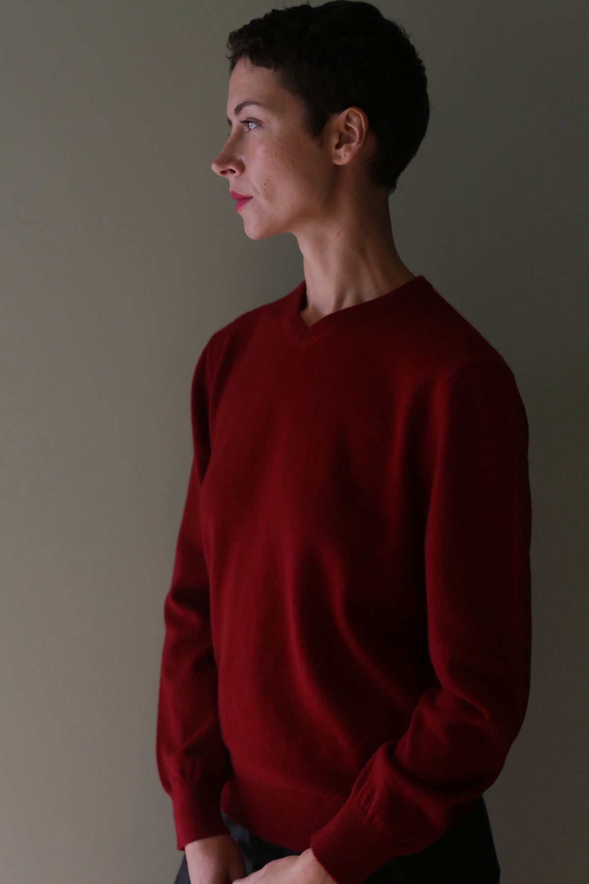A person seen in profile wearing a burgundy High V-Neck Cashmere Sweater.