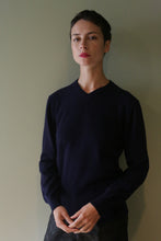 Load image into Gallery viewer, A person wearing a navy High V-Neck Cashmere Sweater with a high V-neckline.