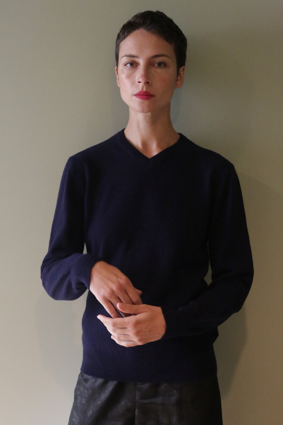 A person wearing a navy blue High V-Neck Cashmere Sweater.