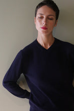 Load image into Gallery viewer, A person wearing a long-sleeved, high V-neck navy blue cashmere sweater.