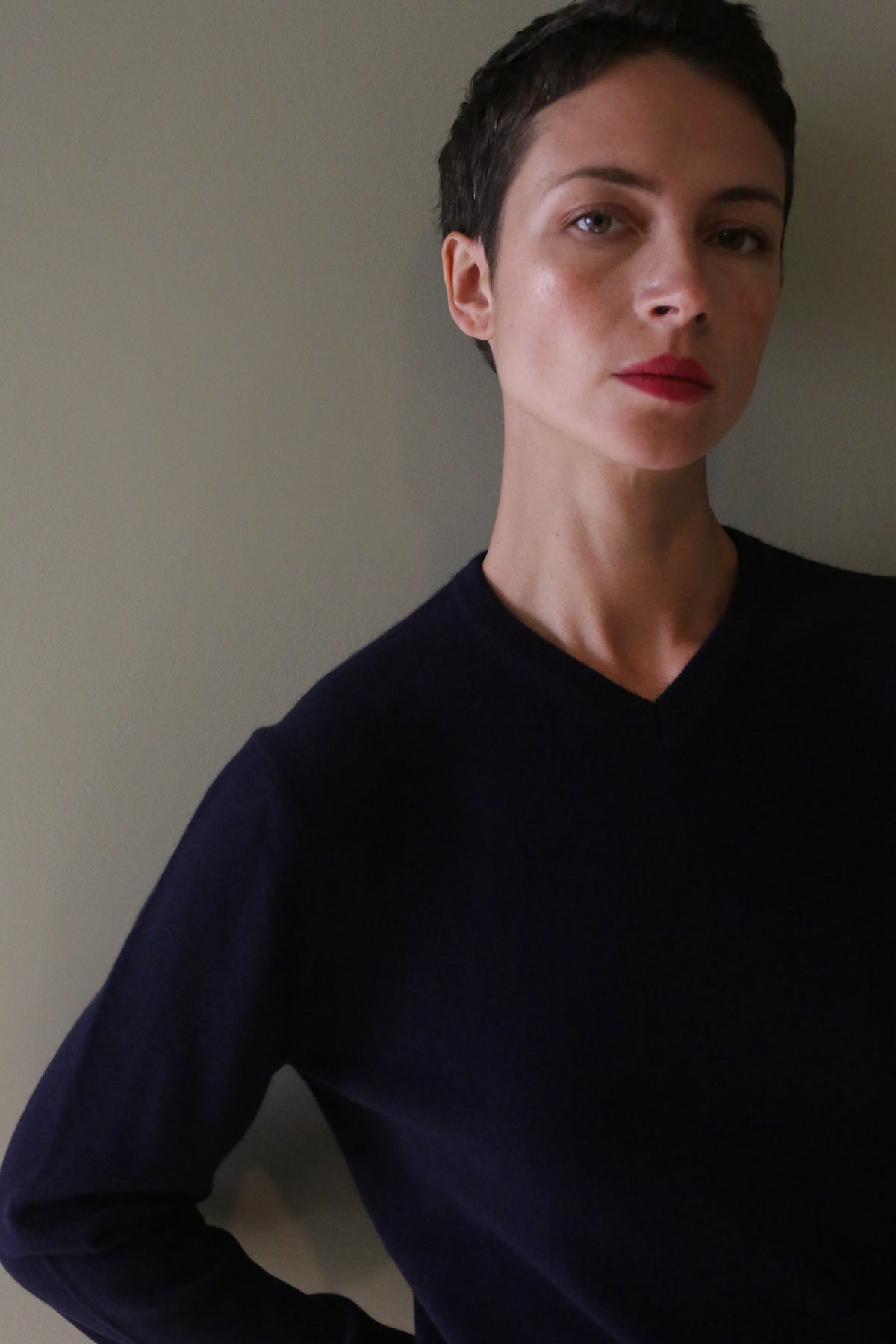 A person wearing a navy High V-Neck Cashmere Sweater.