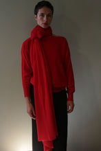 Load image into Gallery viewer, A person wearing a Tissue Weight Cashmere Scarf | Vermillion draped around their neck over a matching red sweater.
