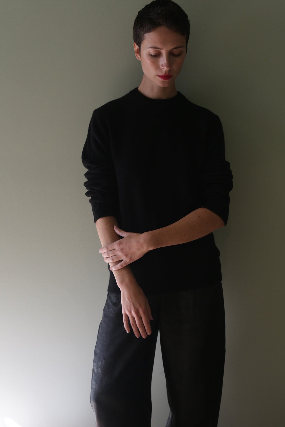 Person wearing a Unisex Heavyweight Cashmere Crewneck | Black with long sleeves and black pants.